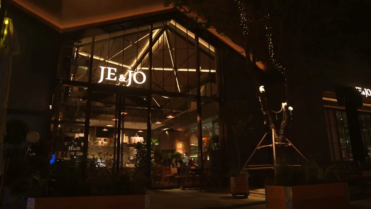 JE&JO 夜晚的店面，橙色招牌亮起